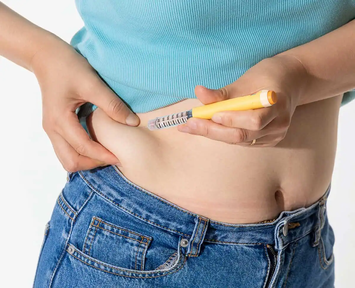 Woman injecting Semaglutide medication into her abdomen with a syringe